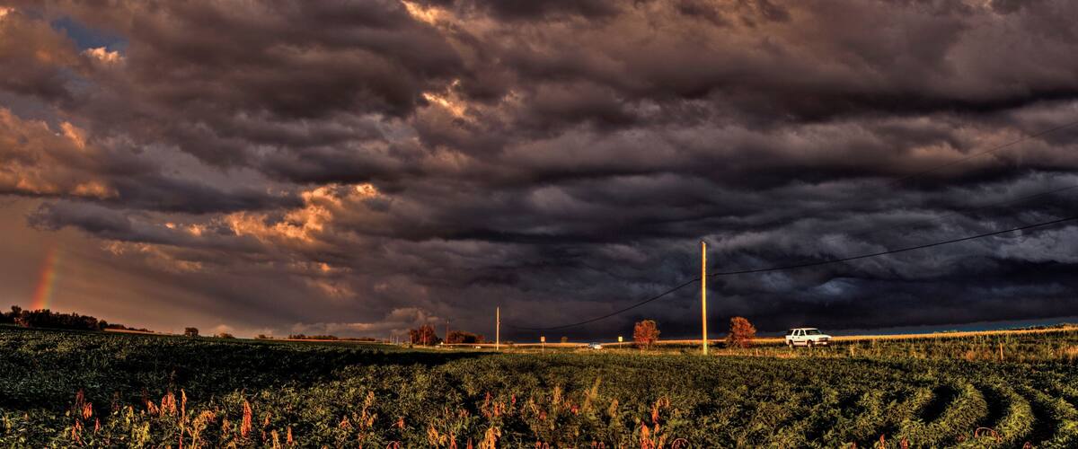 A field with a truck and a power line.
