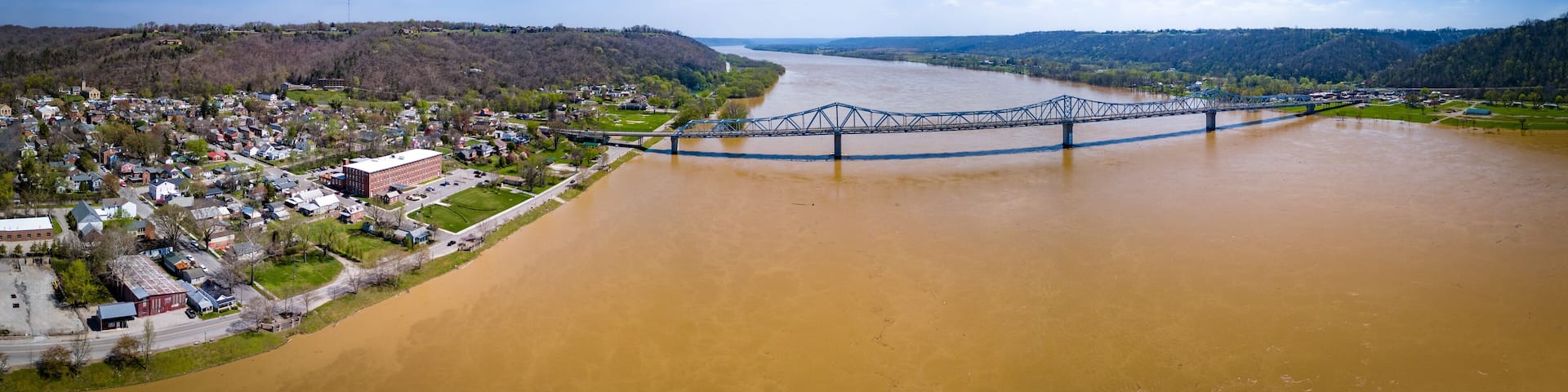Aerial panorama of the bridge linking Madison, Indiana and Milton, Kentucky over brown waters of Ohio river