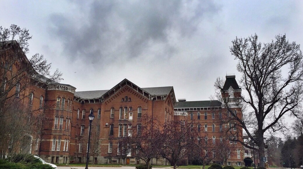 Called "The Ridges" currently, this large, looming building that overlooks Ohio University's campus was formerly a mental health hospital called the Athens Asylum for the Insane. There's a small museum inside now, and the rest of the grounds are owned by the university, but there is still certainly a chilling aspect to the building that calls to its past.
Take a walk around the grounds or visit the museum, it's something worth seeing. Behind the building is a community park with areas that would be worth visiting in warmer days. Take the road that loops up a hill (to the left of a campus sign) and you can view the cemetery of unnamed, forgotten patients who died and were only assigned a number. There are efforts to find the names of these individuals and give them the attention that is deserved. There's also a beautiful nature walk that I would have taken if it wasn't so cold!
#roadtrips #ohio #historic #hospitals #roadtrip
