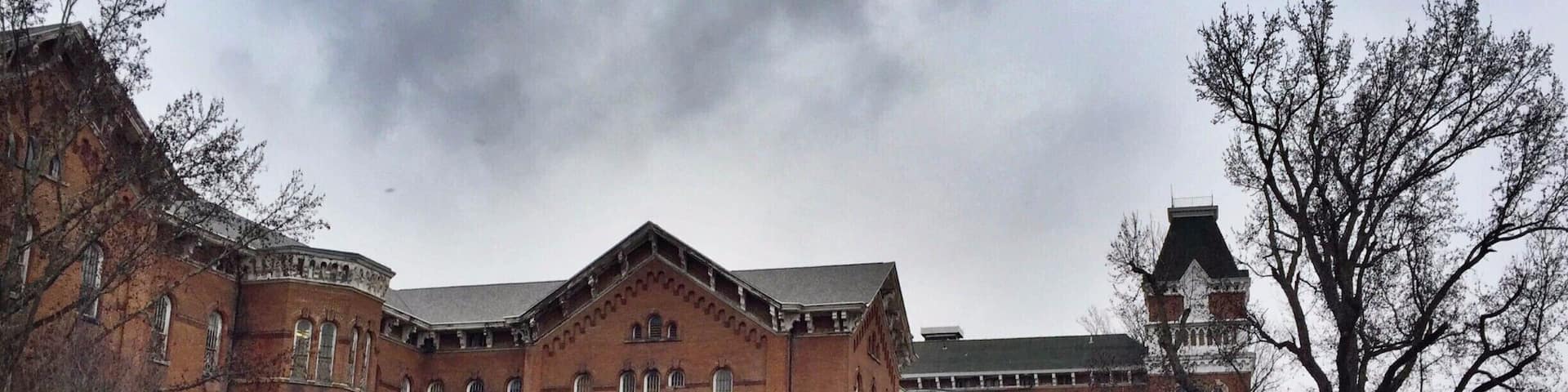 Called "The Ridges" currently, this large, looming building that overlooks Ohio University's campus was formerly a mental health hospital called the Athens Asylum for the Insane. There's a small museum inside now, and the rest of the grounds are owned by the university, but there is still certainly a chilling aspect to the building that calls to its past.
Take a walk around the grounds or visit the museum, it's something worth seeing. Behind the building is a community park with areas that would be worth visiting in warmer days. Take the road that loops up a hill (to the left of a campus sign) and you can view the cemetery of unnamed, forgotten patients who died and were only assigned a number. There are efforts to find the names of these individuals and give them the attention that is deserved. There's also a beautiful nature walk that I would have taken if it wasn't so cold!
#roadtrips #ohio #historic #hospitals #roadtrip