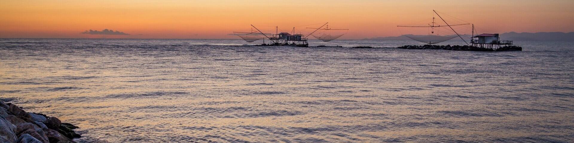 There is a lot more to Pisa than the famous Leaning Tower!
If you get some extra time, I would recommend you hit the Marina di Pisa. It is only a 20 mins drive from the city, and in my opinion it is worth the detour.
The walk at sunset by the Arno bank in the estuary is brilliant. This is from there that I got this photo of those fishing huts.
Also, the Yacht Club in the middle of the marina is an amazing spot to watch sunset and enjoy a Spritz!