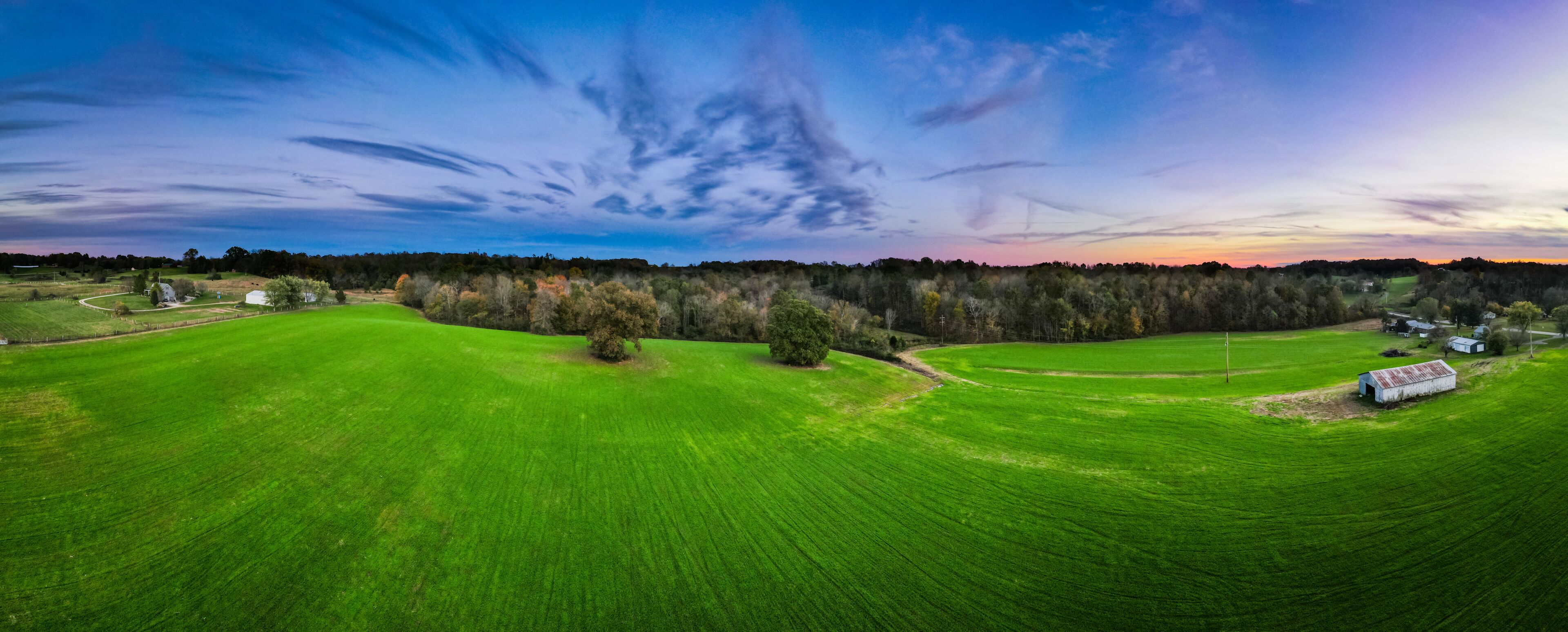 Bright green meadow around Glasgow, Kentucky with colorful sky sunset