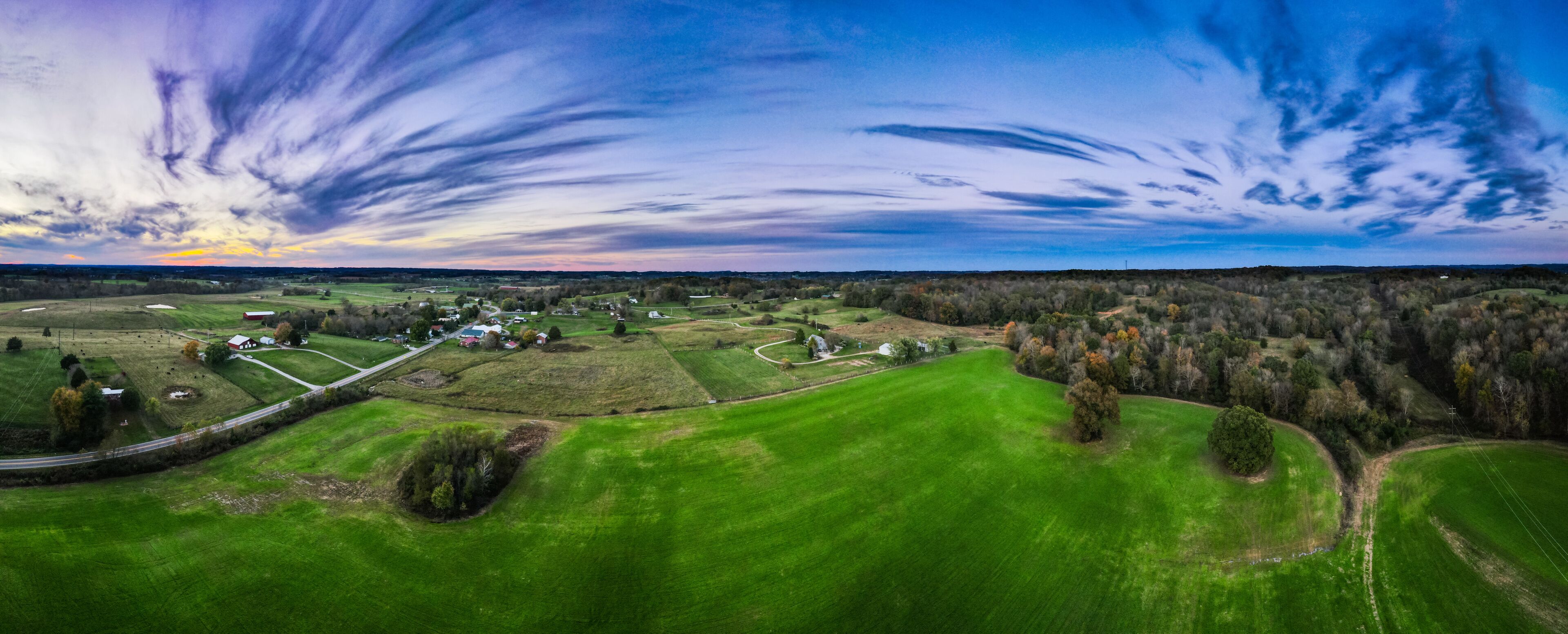 Bright green meadow around Glasgow, Kentucky with colorful sky sunset