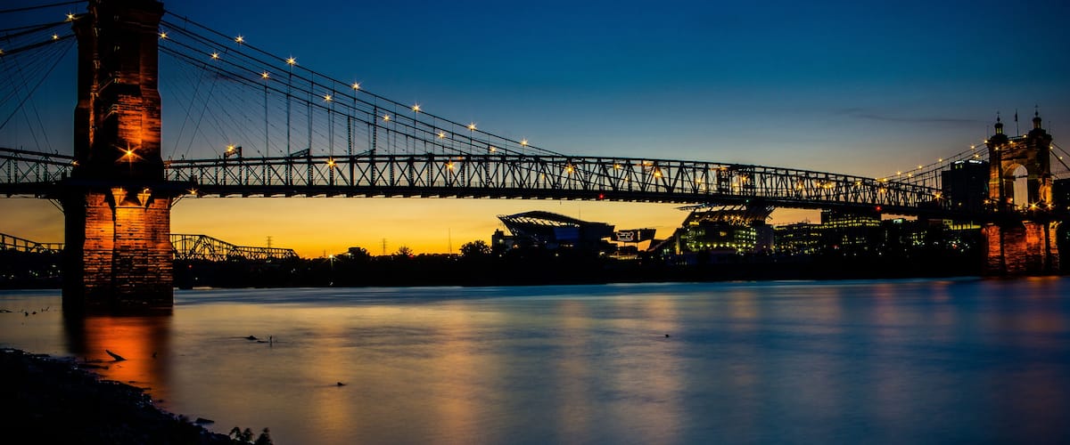 A bridge at dusk with lights reflecting on the water.