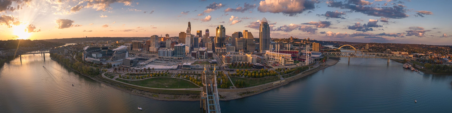 A city skyline with a river, a bridge, and a stadium.