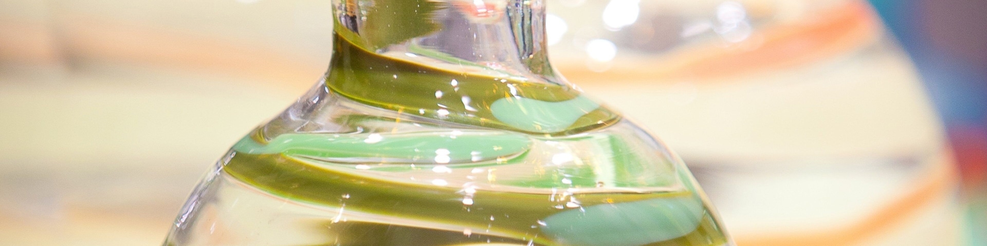 A clear glass bottle with green liquid.
