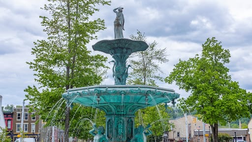 The Broadway Fountain in Madison, Indiana with spring trees, and clouds.
