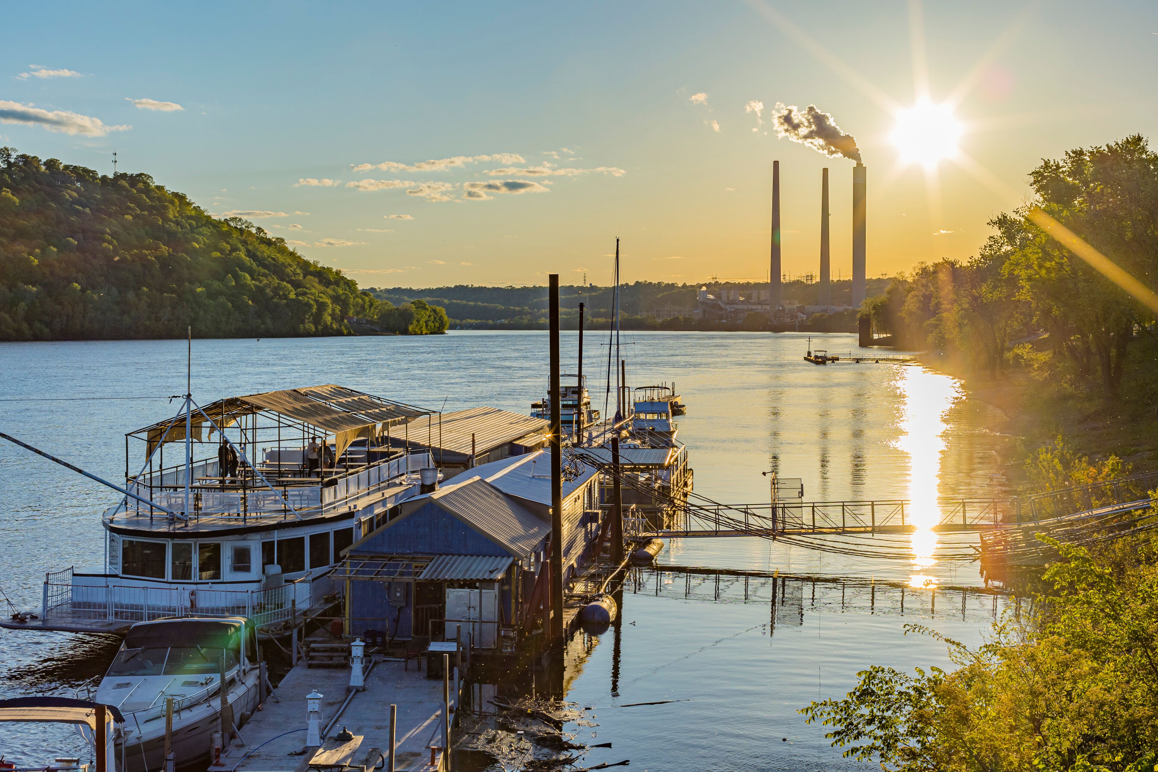 Shoreline of the Ohio River and the marina at Madison, Indiana at sunset with the power plant in the background.