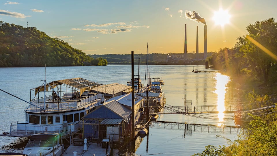 Shoreline of the Ohio River and the marina at Madison, Indiana at sunset with the power plant in the background.