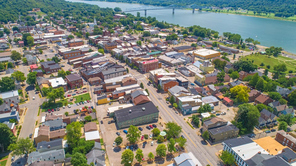 A town with a river, a bridge, and a mix of historic and modern buildings.