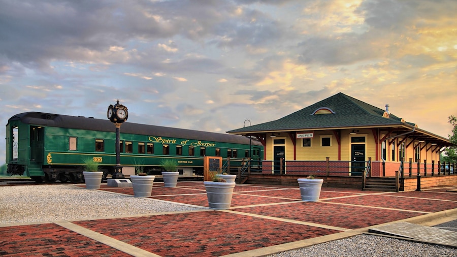 A vintage train station with a green train labeled 'Spirit of Jasper' and a waiting room.