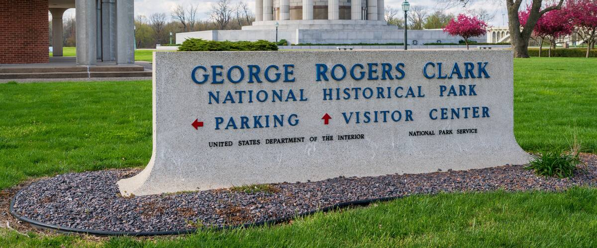 A sign for the George Rogers Clark National Historical Park, indicating directions to the parking and visitor center.