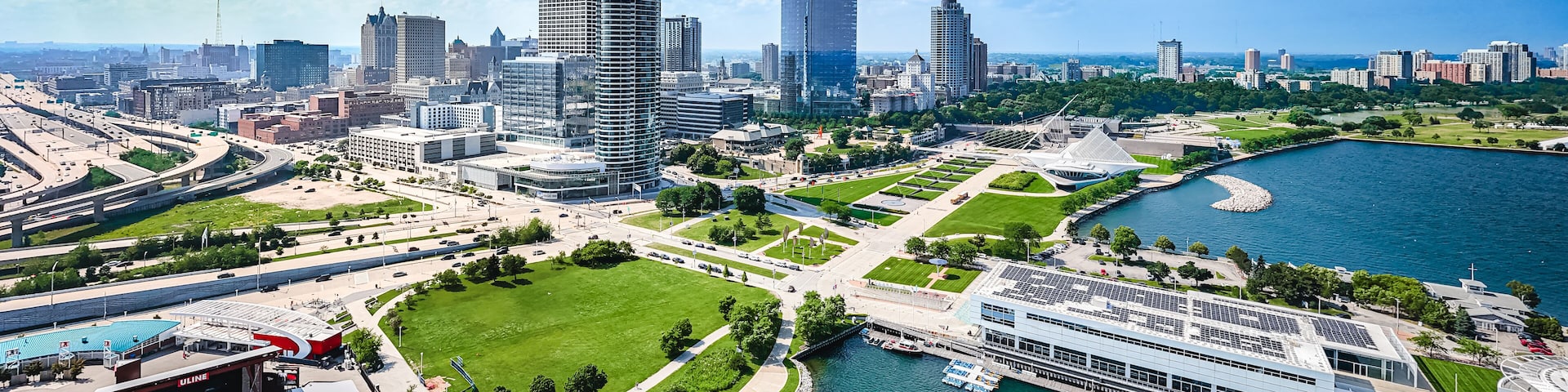 A cityscape with a river, green spaces, and modern buildings.