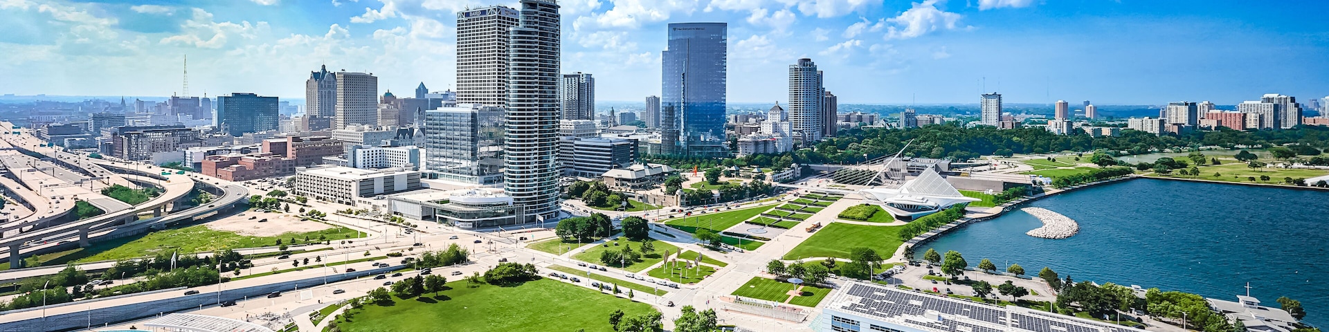 Un paisaje urbano con un río, zonas verdes y edificios modernos.