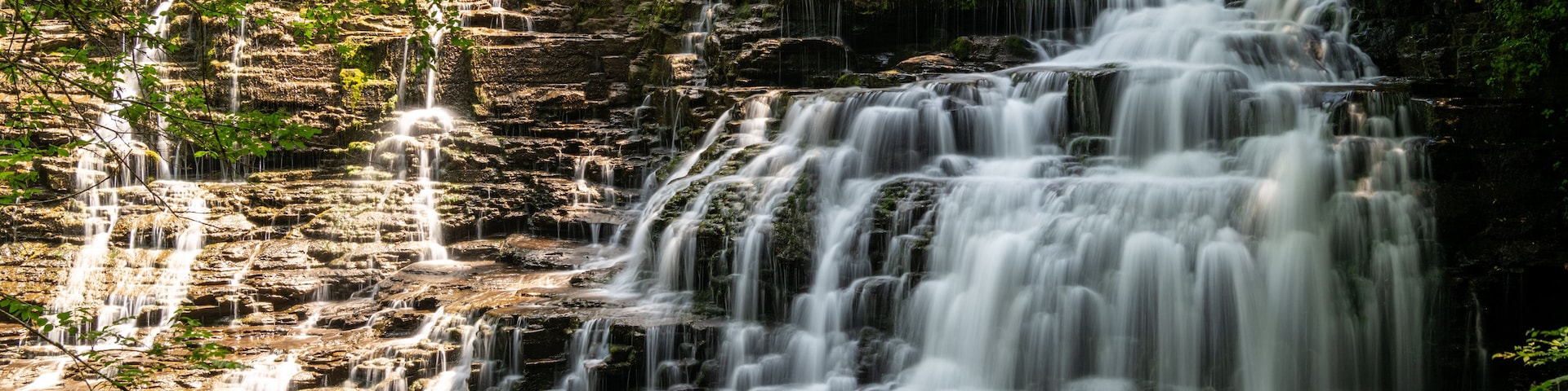 Una cascada de varios niveles rodeada de exuberante vegetación.