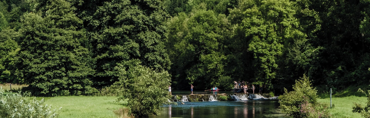 Swimmers and boaters in the Wiesent beneath the ruin Neideck in Streitberg