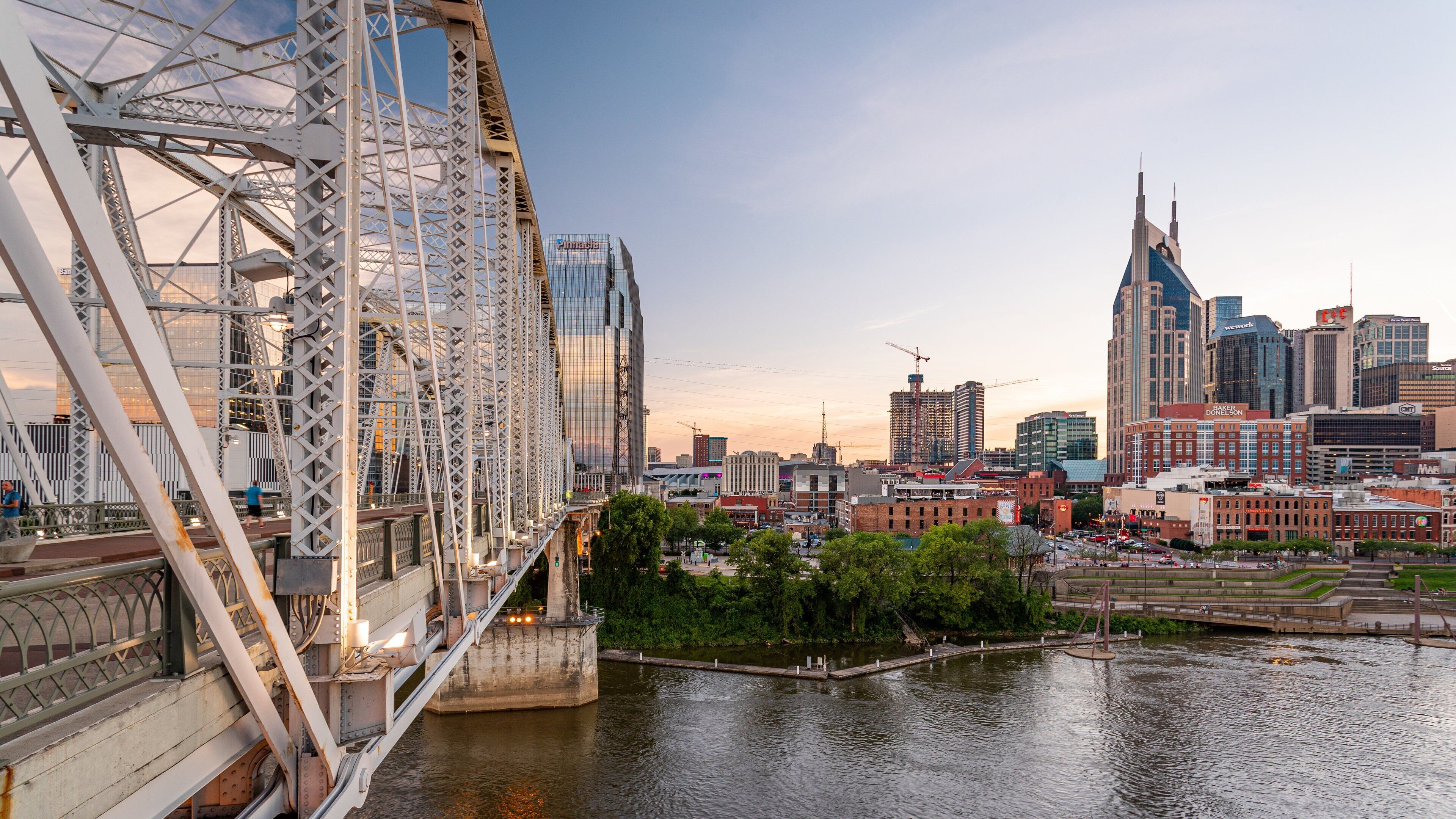 Eine Skyline mit einem großen Riesenrad, modernen Wolkenkratzern und einem Fluss.