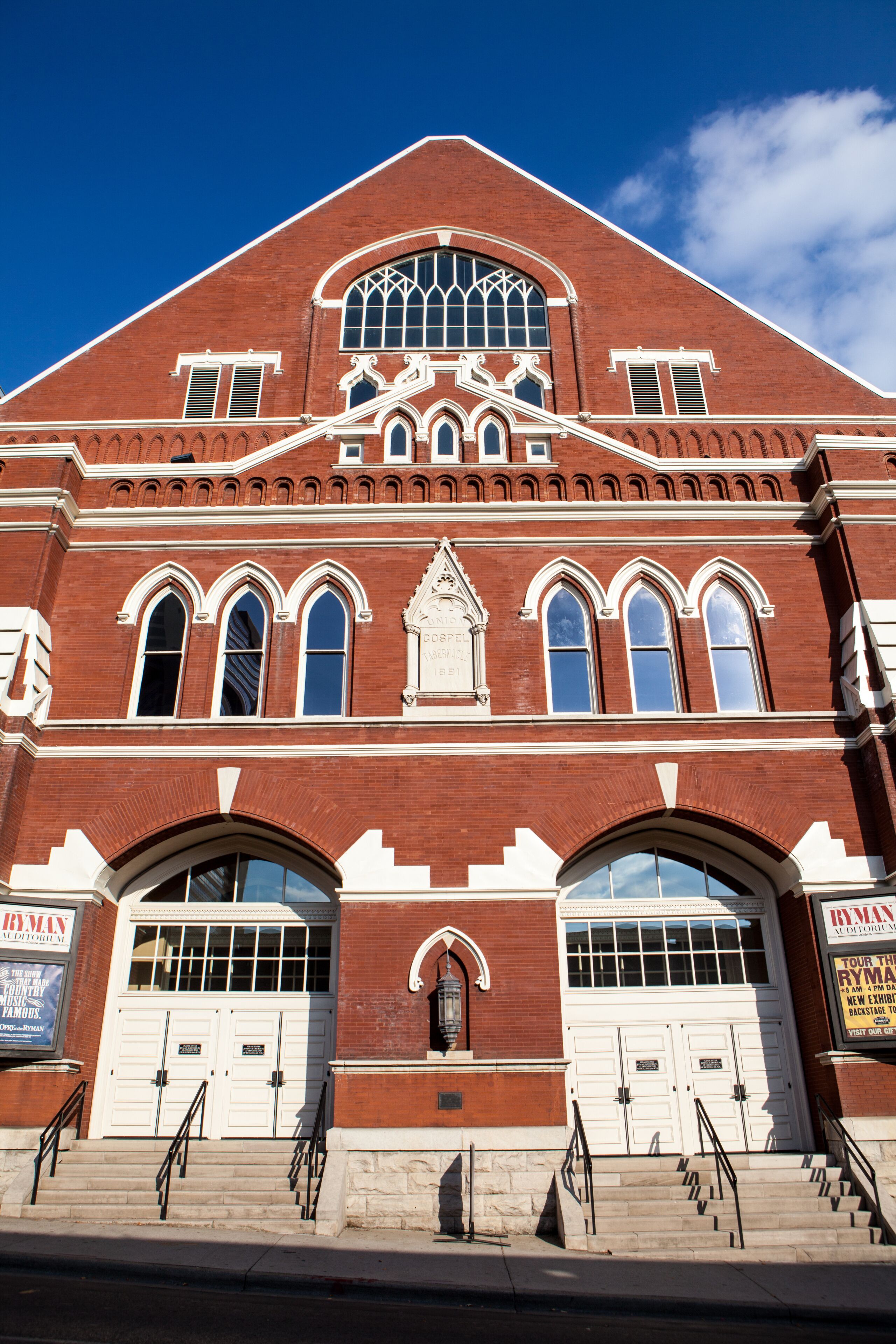A red brick building with arched windows and a clock tower.
