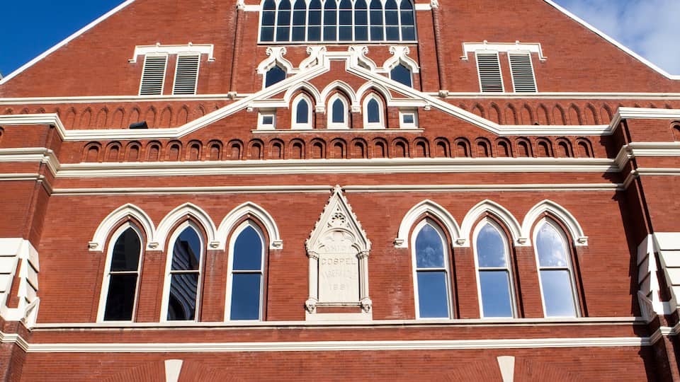 A red brick building with arched windows and a clock tower.