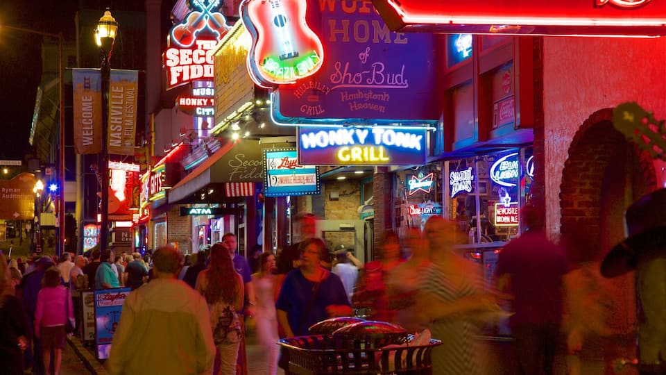 A bustling street with neon signs, including 'The Second Fiddle' and 'Honk Your Grill'.