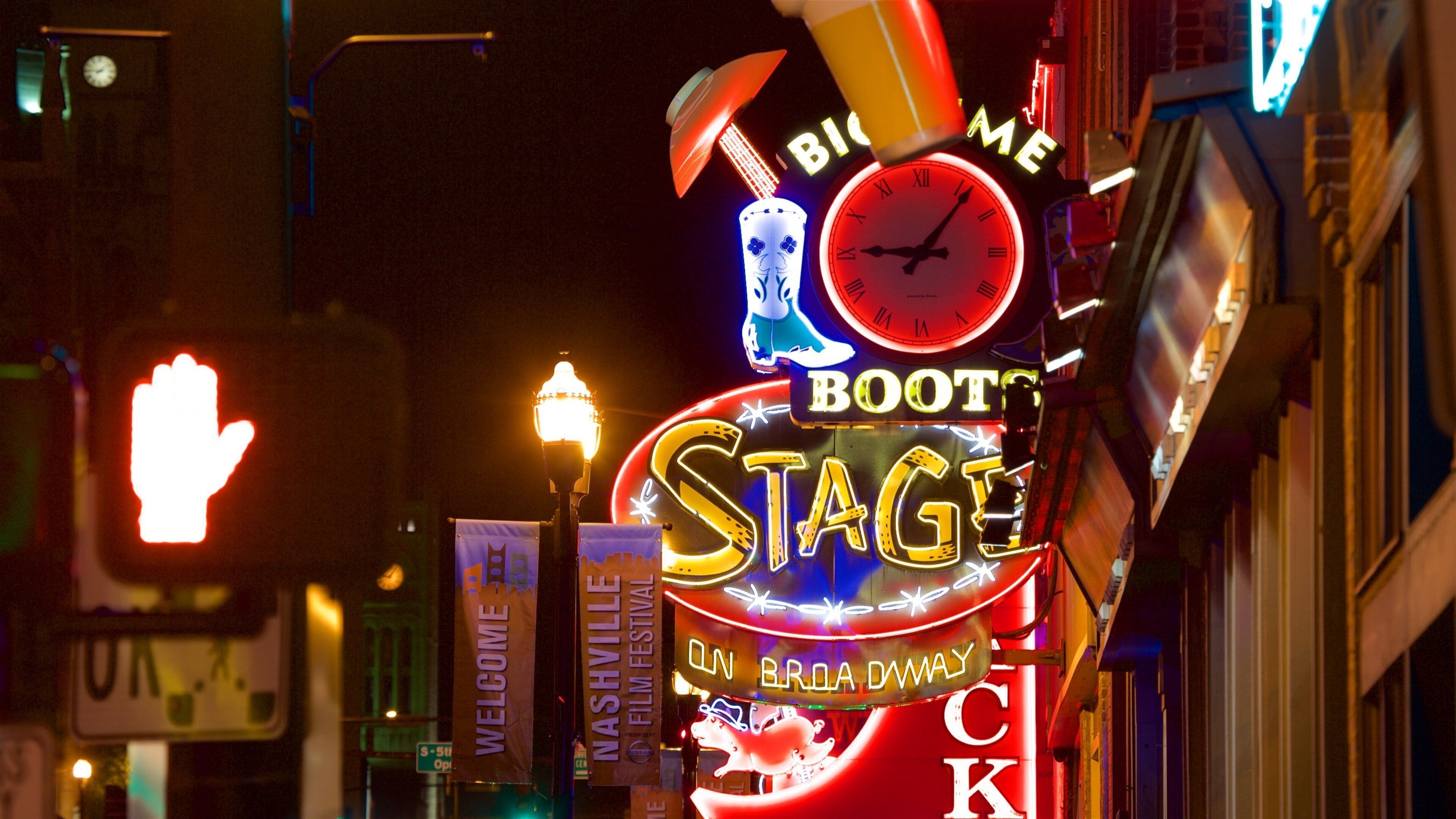 En neonskilte med teksten 'Stage' og 'Nashville Film Festival', et 'Velkommen'-banner og et skilt med 'BooT'.