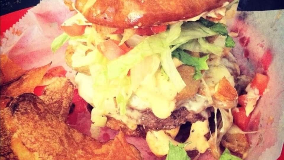 Literally the best burger I've had in my life. Burger topped with bacon, fried pickles, French fries, and cheese on a pretzel bun!