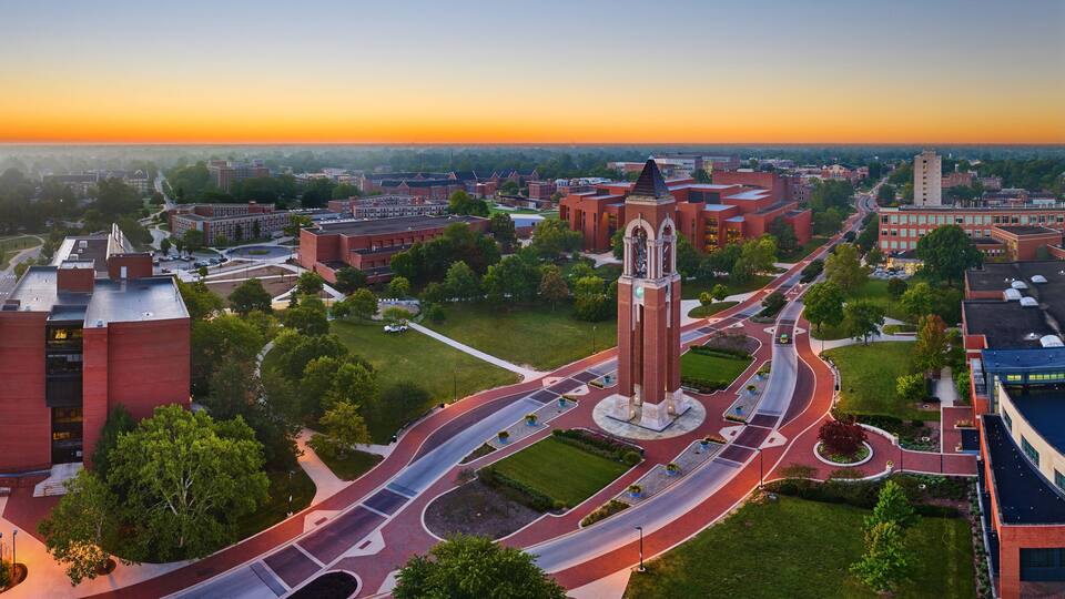 A campus with a prominent clock tower, interconnected roads, and surrounding buildings.