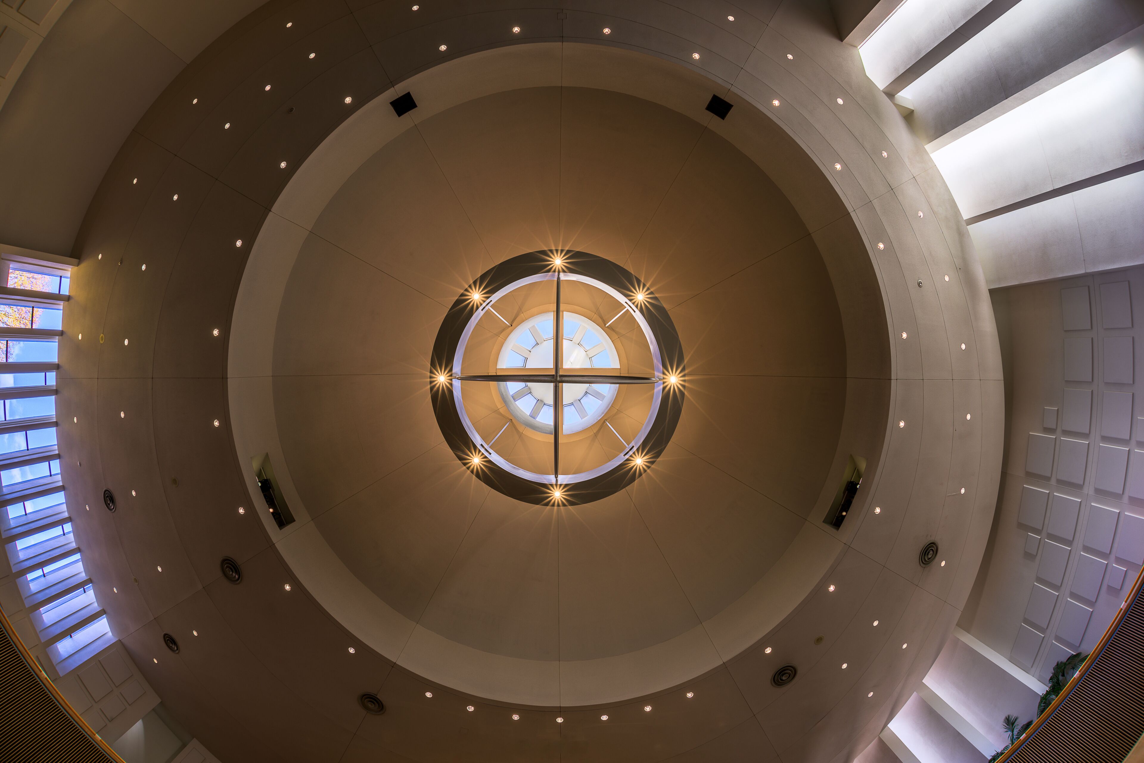 A circular architectural structure with a central skylight and surrounding recessed lighting.