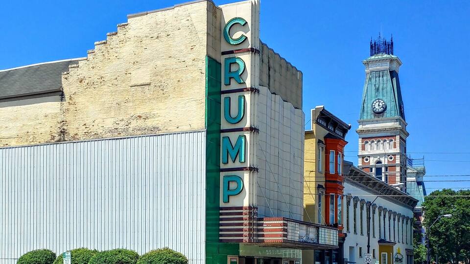 A street with a building labeled "CRUMP" and a clock tower in the background.