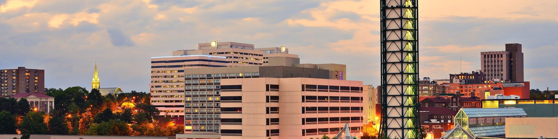 A cityscape with a prominent spherical tower, modern buildings, and a bridge.