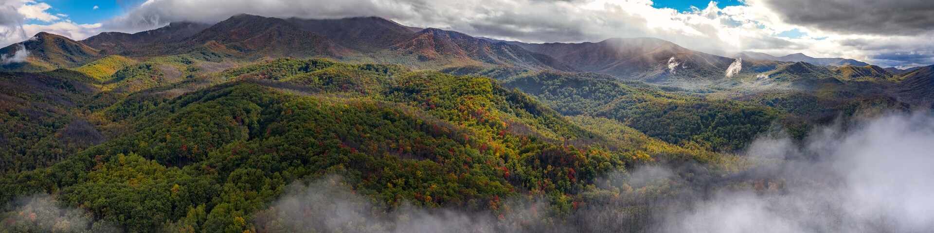 A mountainous landscape with dense forests and mist-covered peaks.