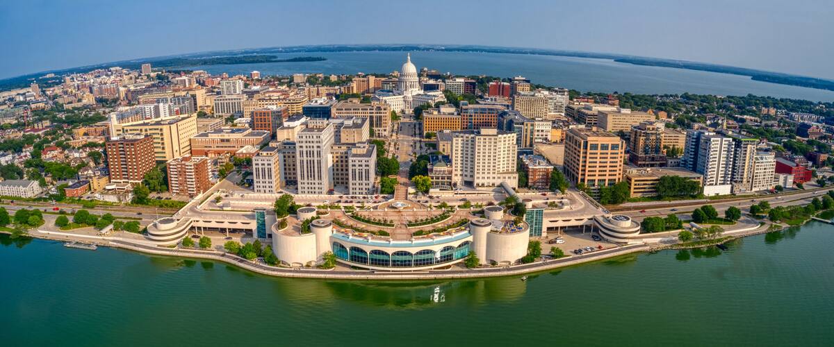 An aerial view of a city with a prominent white dome building, a river, and surrounding urban landscape.