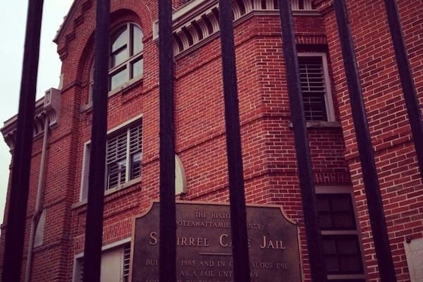 A brick building with a plaque reading "SIRREL C JAIL".