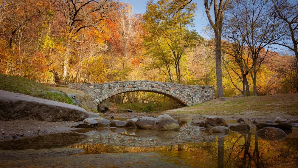 Pedestrian rock bridge over Peas Creek in Ledges State Park, Iowa, during fall