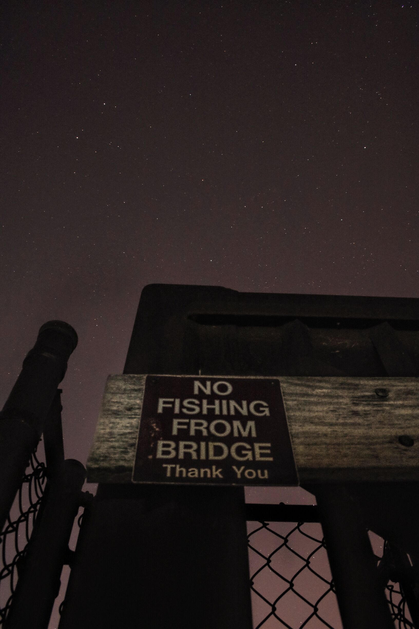 A no fishing sign hangs on the arch bridge across Ada Hayden Heritage Park Lake. 