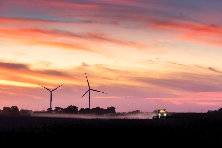 tractor harvesting a field at sunset on a Iowa farm