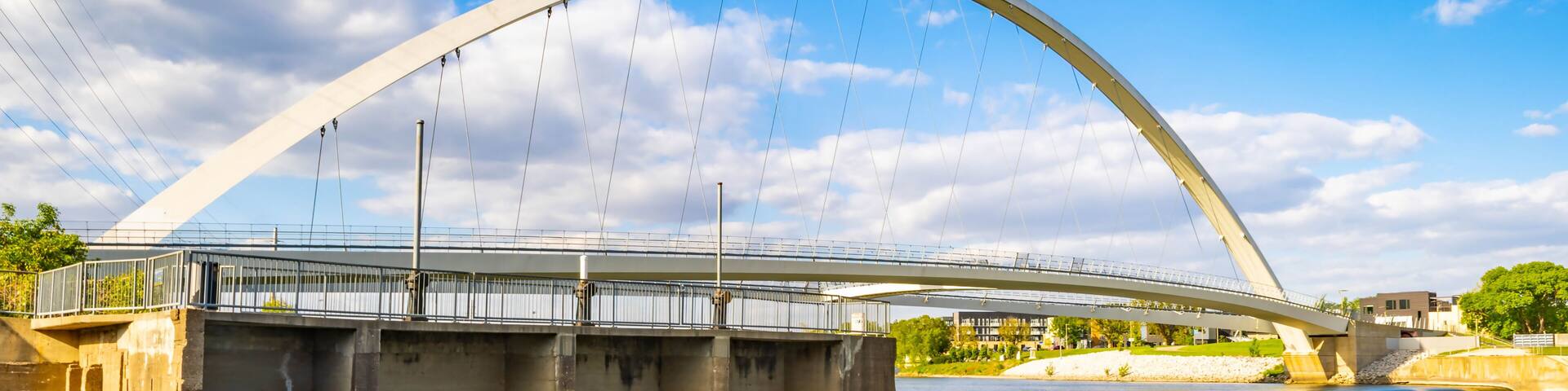 A large arched bridge over a river with a clear sky.
