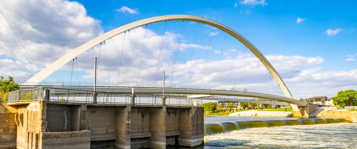 A large arched bridge over a river with a clear sky.