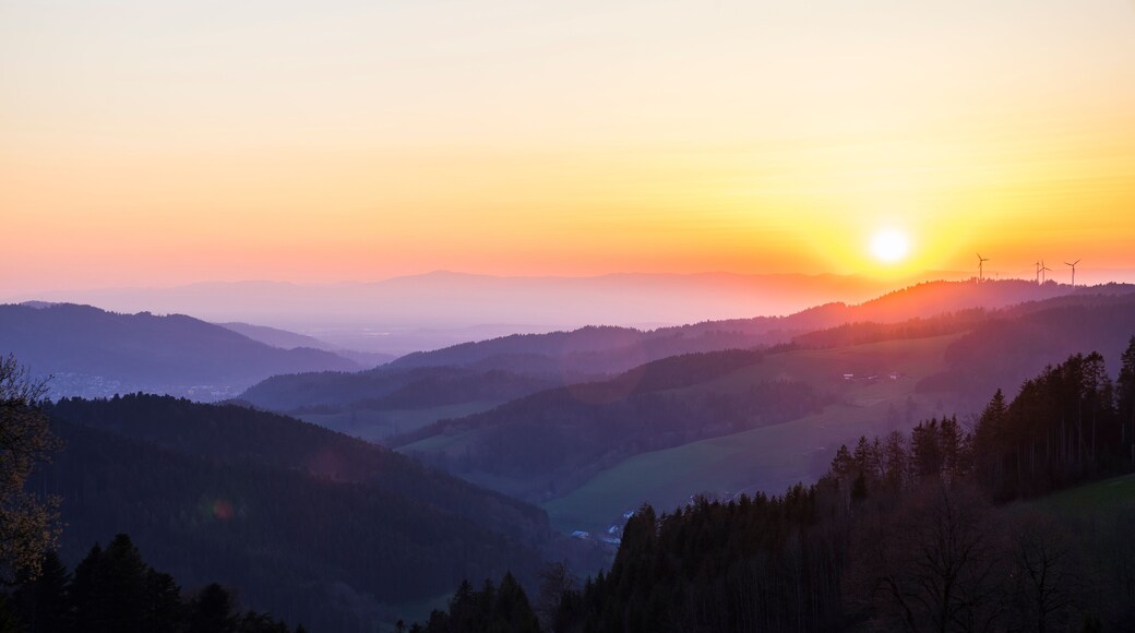 Germany, Romantic orange sunset sky over mountains silhouette in nature landscape of black forest scenery with view from lindenberg mountain