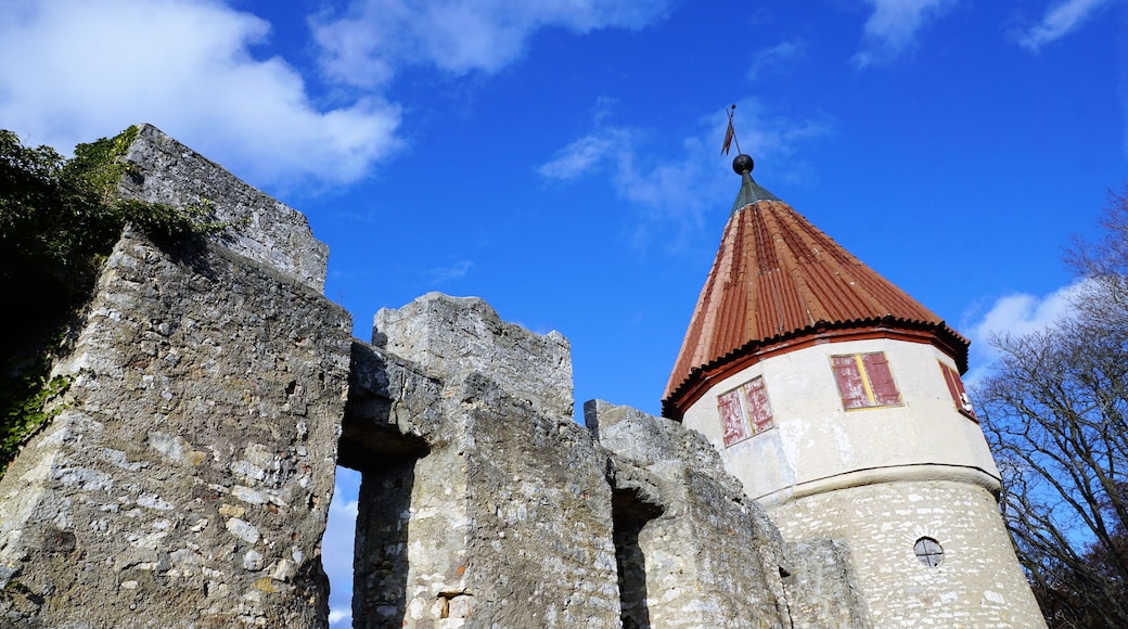 A stone tower with a red roof and a weather vane.