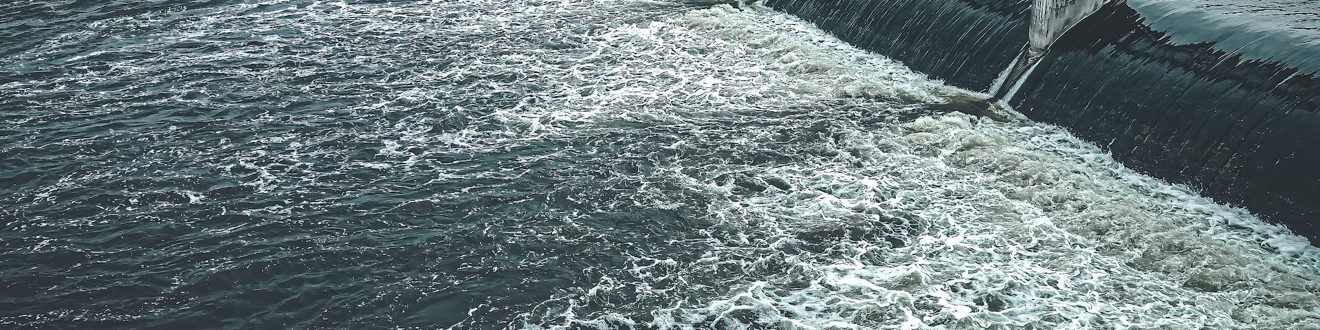 A river with a dam and a bridge.