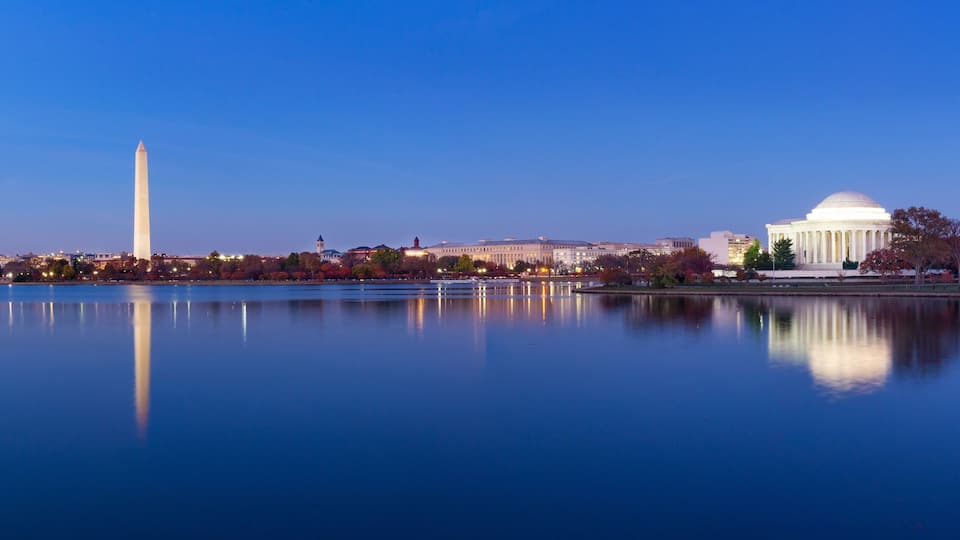 The Washington Monument, the Lincoln Memorial, and the National Mall with a calm lake reflecting the buildings.