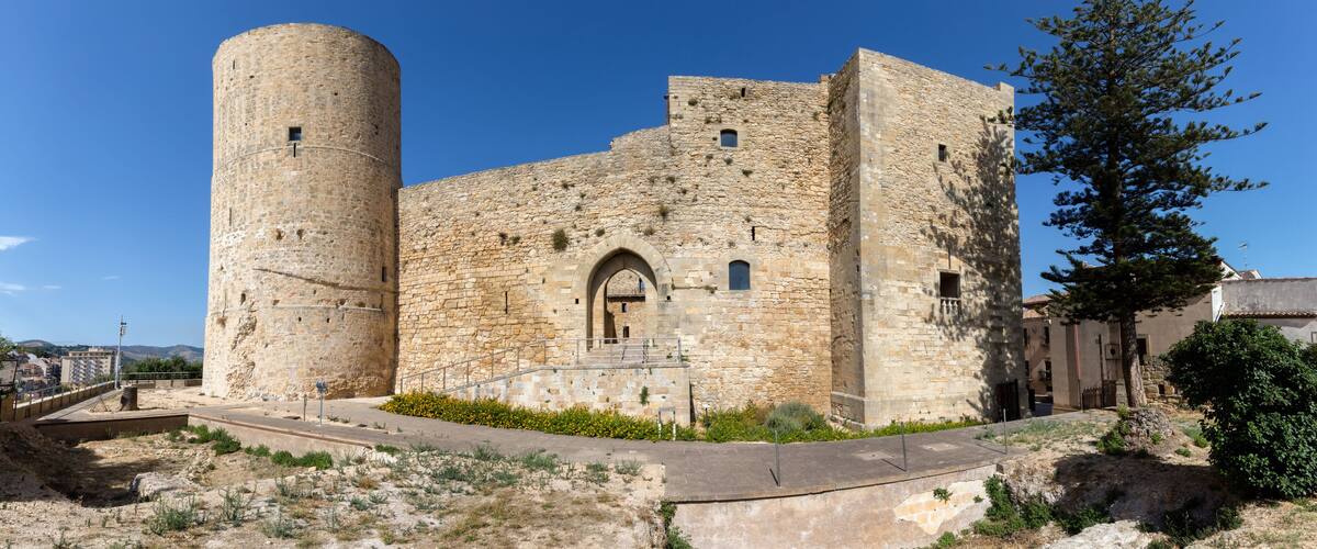 A historic stone castle with a round tower and arched entrance.