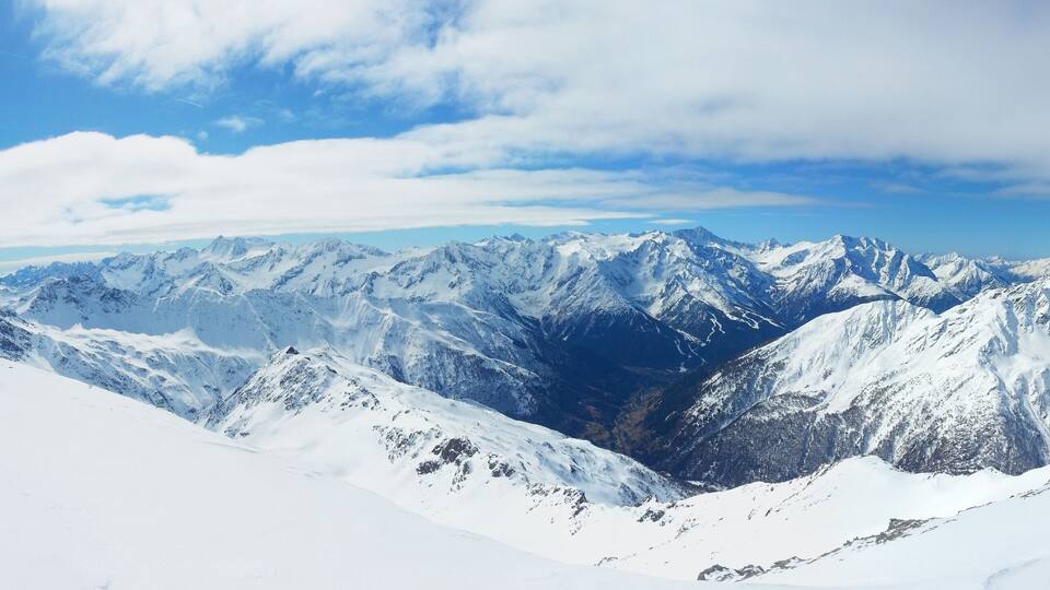A snow-covered mountain range with a clear sky.