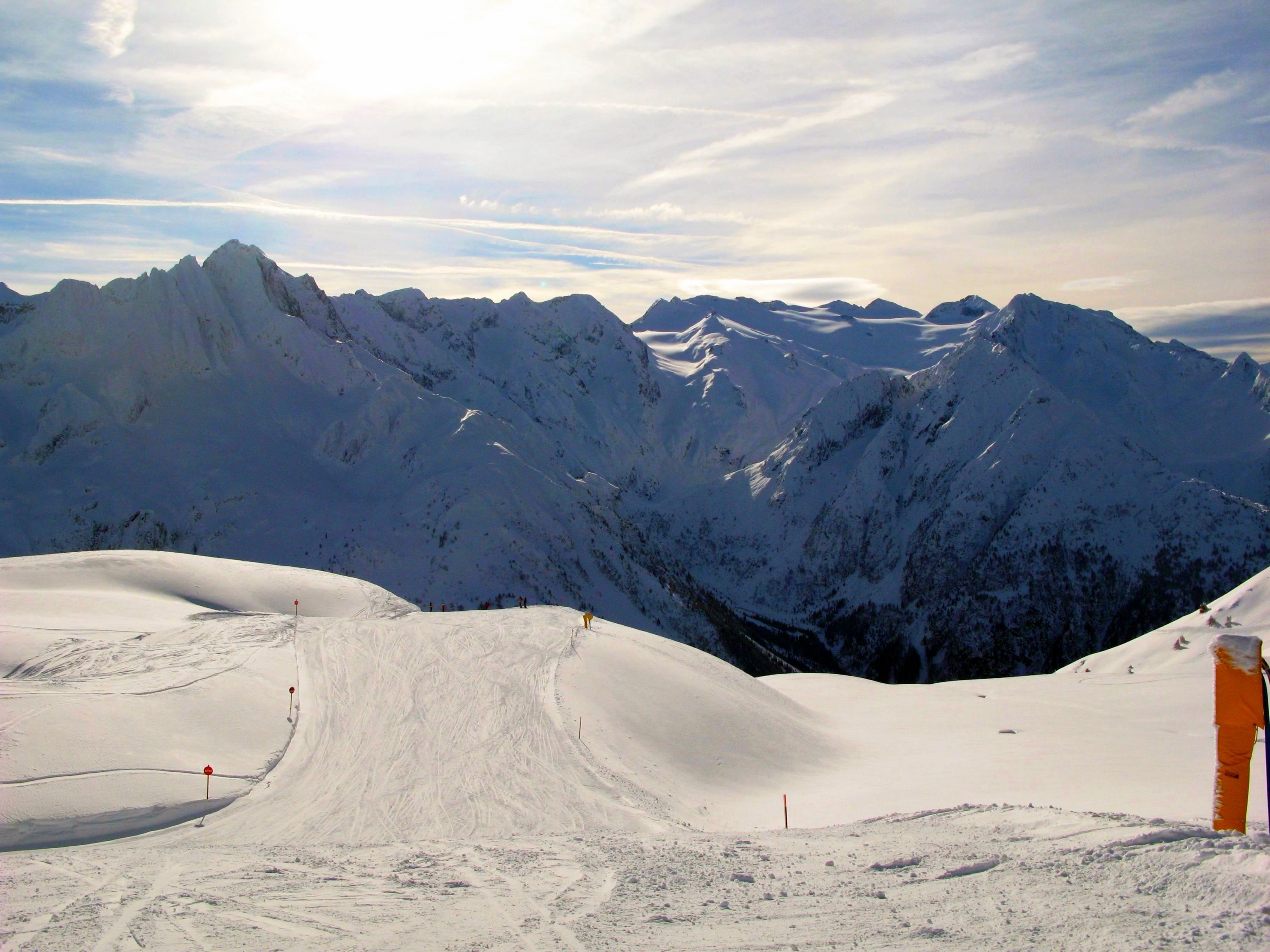 A snow-covered mountain landscape with ski slopes and a ski lift.