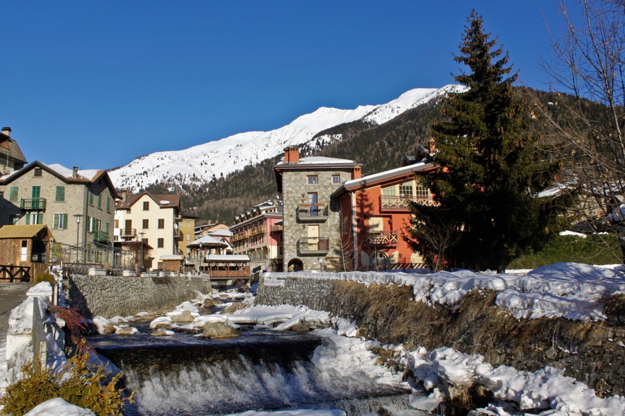 Houses in mountain landscape during winter on the foreground, mountain peak on the background.Apartments in Ponte di Legno, Italy