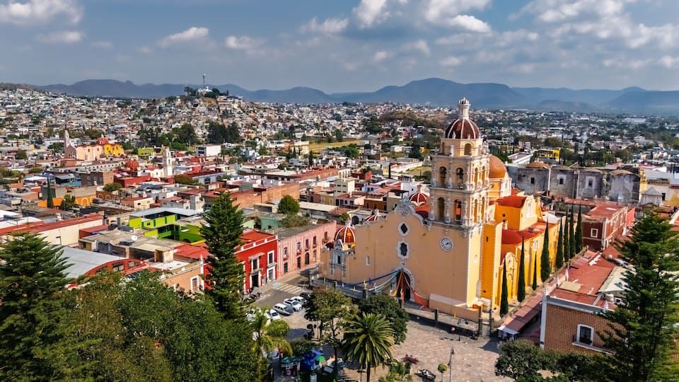 A cityscape with a prominent church featuring a large dome and bell tower.