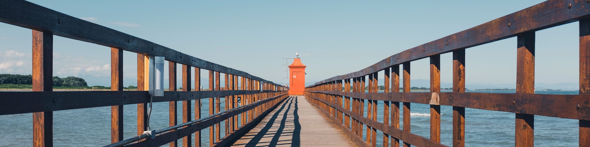 Distant view of lighthouse on pier against clear sky