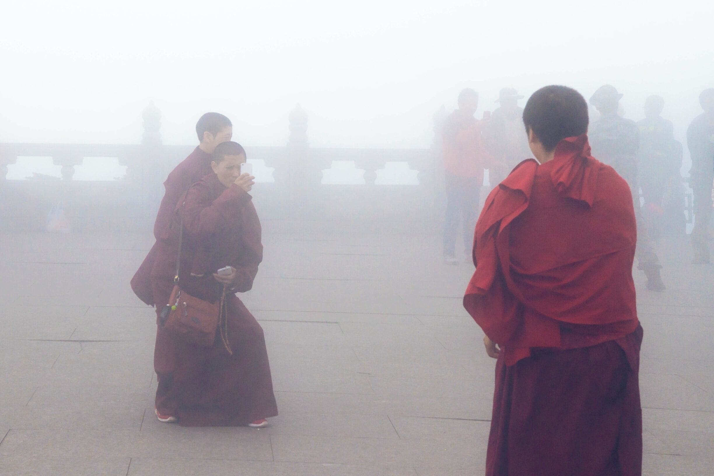 A few buddhist monks enjoying a photo opp at the top of Mount Emei as the fog rolls in.