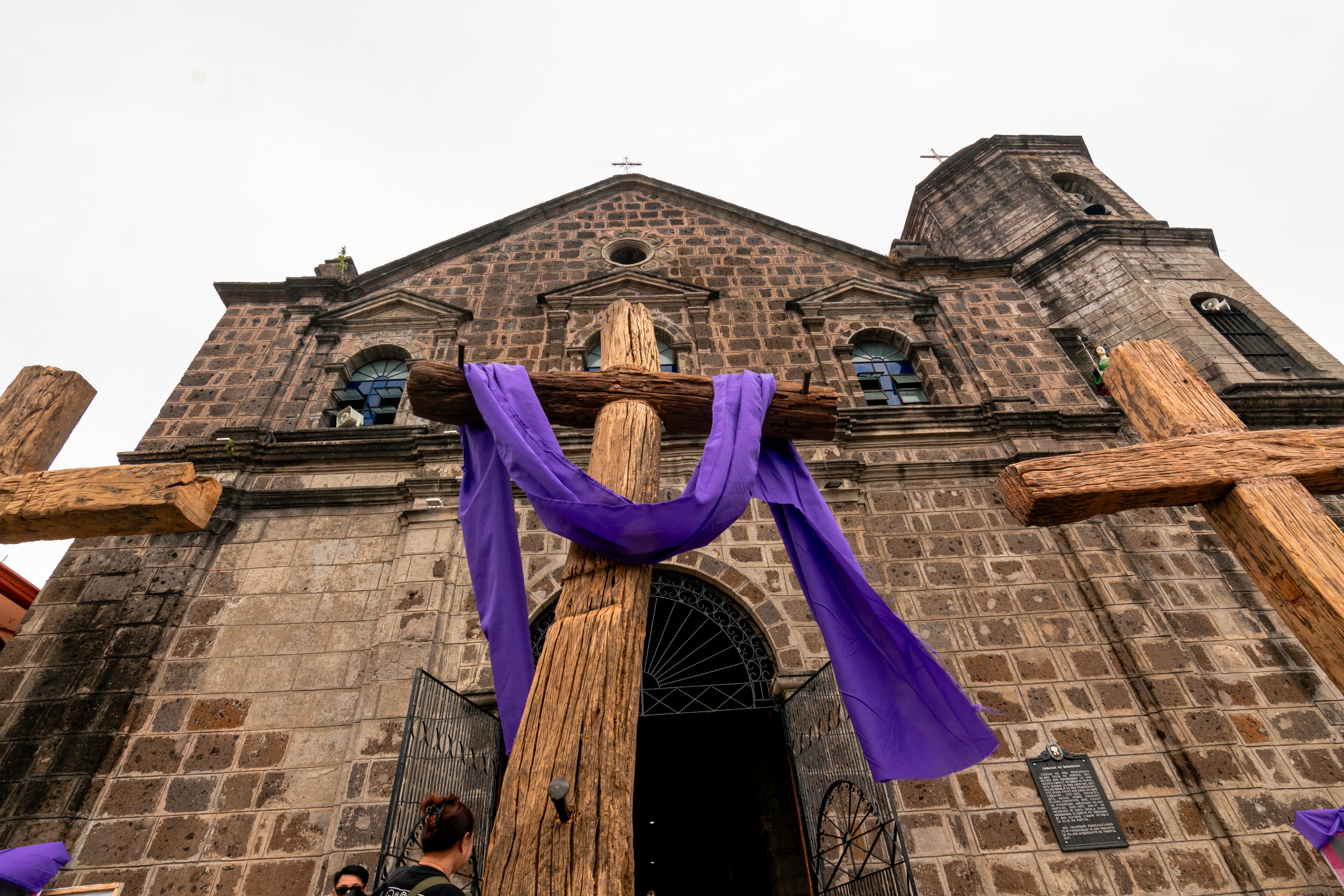 A historic church with large wooden crosses and purple drapes.